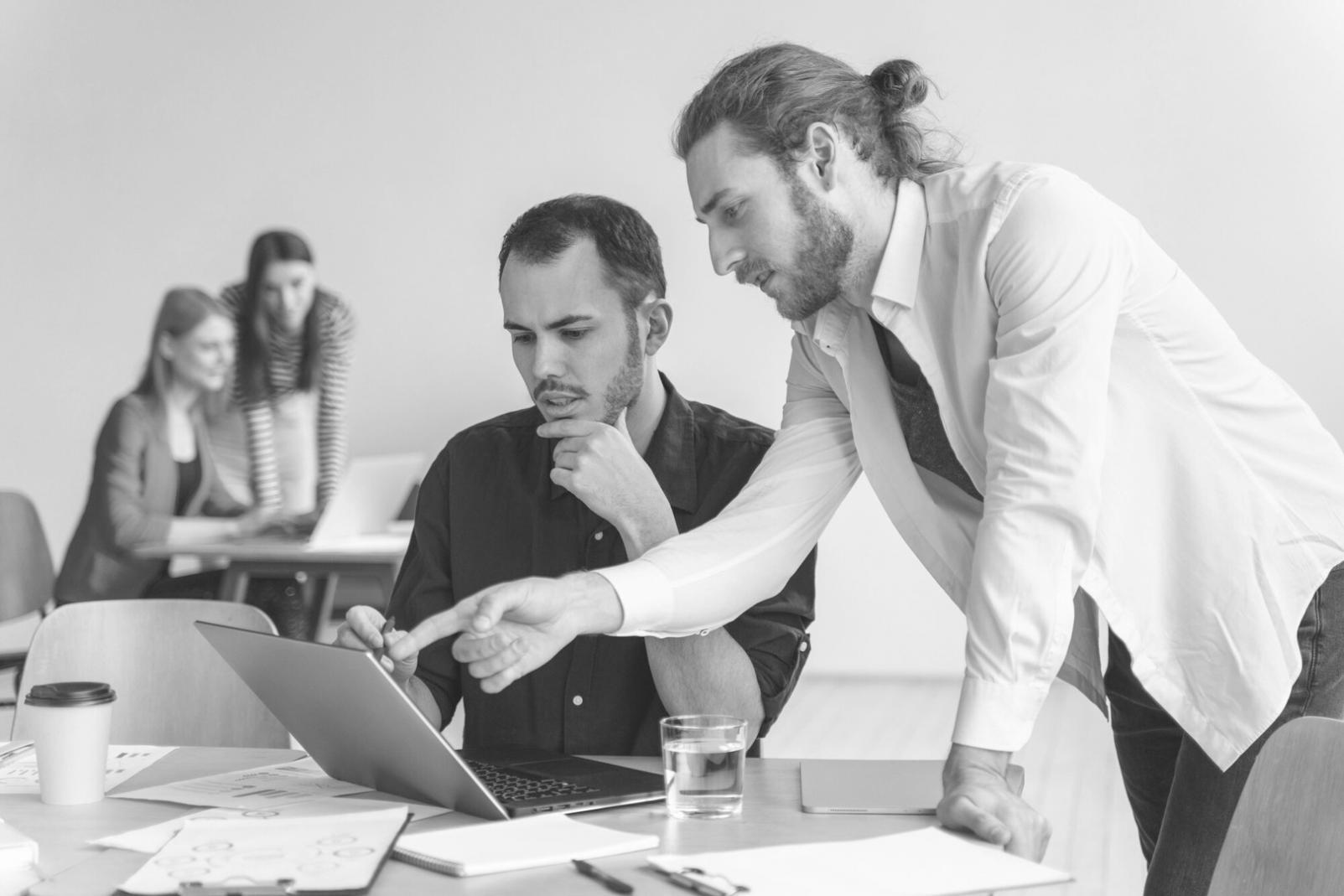 Investment professional conducting detailed financial analysis with spreadsheet models and market data